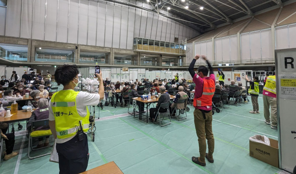 腕を上にのばすスタッフ